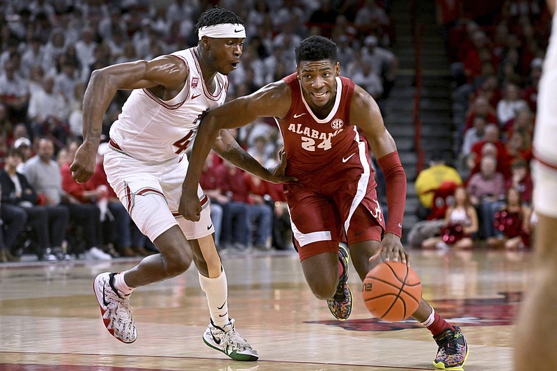 Alabama forward Brandon Miller (24) tries to get past Arkansas guard Davonte Davis (4) during the first half of an NCAA college basketball game Wednesday, Jan. 11, 2023, in Fayetteville, Ark. (AP Photo/Michael Woods)