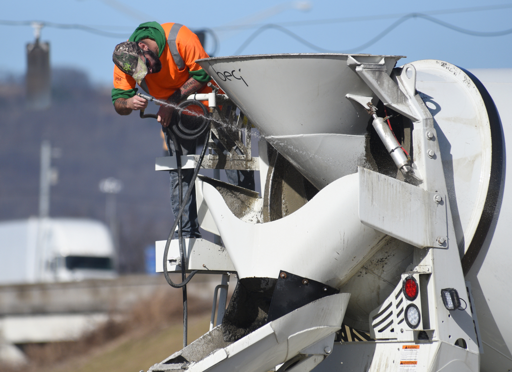 Staff photo by Matt Hamilton / A worker cleans the spout of a cement truck as construction continues on the onramp between Market Street and I-24 on Thursday, January 19, 2023. The contractor, Charleston, Tennessee-based Wright Brothers Construction, this week has been working on new bridge construction, storm drainage structures and utility relocation in the ongoing I-24 interchange improvement project in Chattanooga, according to the Tennessee Department of Transportation. The project is expected to be finished by the end of August.