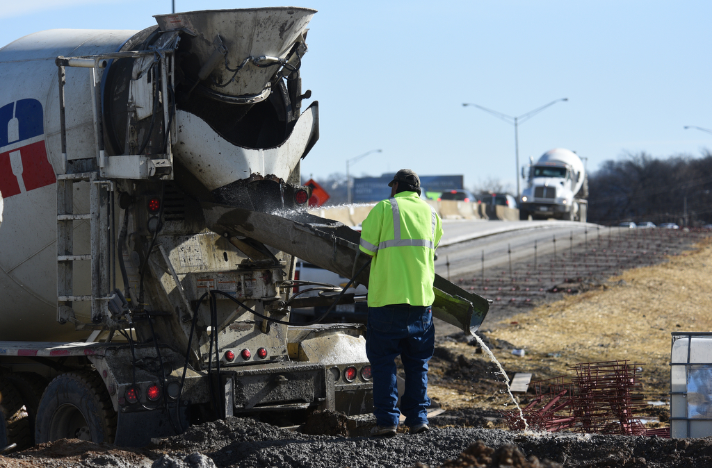 Staff photo by Matt Hamilton / A worker cleans the spout of a cement truck as construction continues on the onramp between Market Street and I-24 on Thursday, January 19, 2023. The contractor, Charleston, Tennessee-based Wright Brothers Construction, this week has been working on new bridge construction, storm drainage structures and utility relocation in the ongoing I-24 interchange improvement project in Chattanooga, according to the Tennessee Department of Transportation. The project is expected to be finished by the end of August.