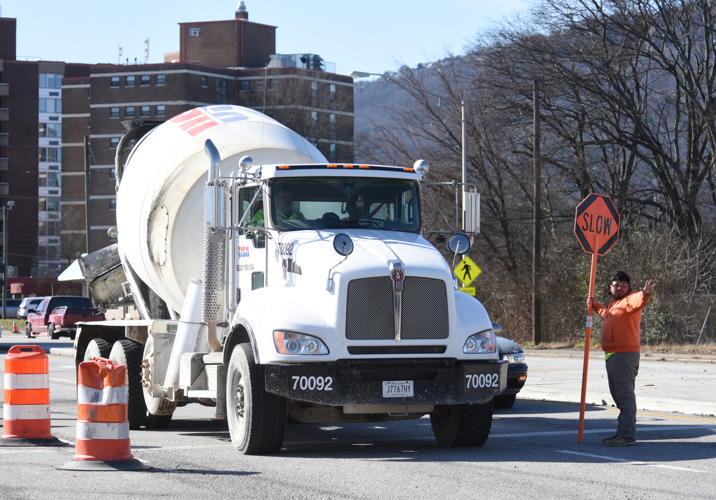 Staff photo by Matt Hamilton / A worker pauses traffic as a cement truck brings cement as construction continues on the onramp between Market Street and I-24 on Thursday, January 19, 2023. The contractor, Charleston, Tennessee-based Wright Brothers Construction, this week has been working on new bridge construction, storm drainage structures and utility relocation in the ongoing I-24 interchange improvement project in Chattanooga, according to the Tennessee Department of Transportation. The project is expected to be finished by the end of August.