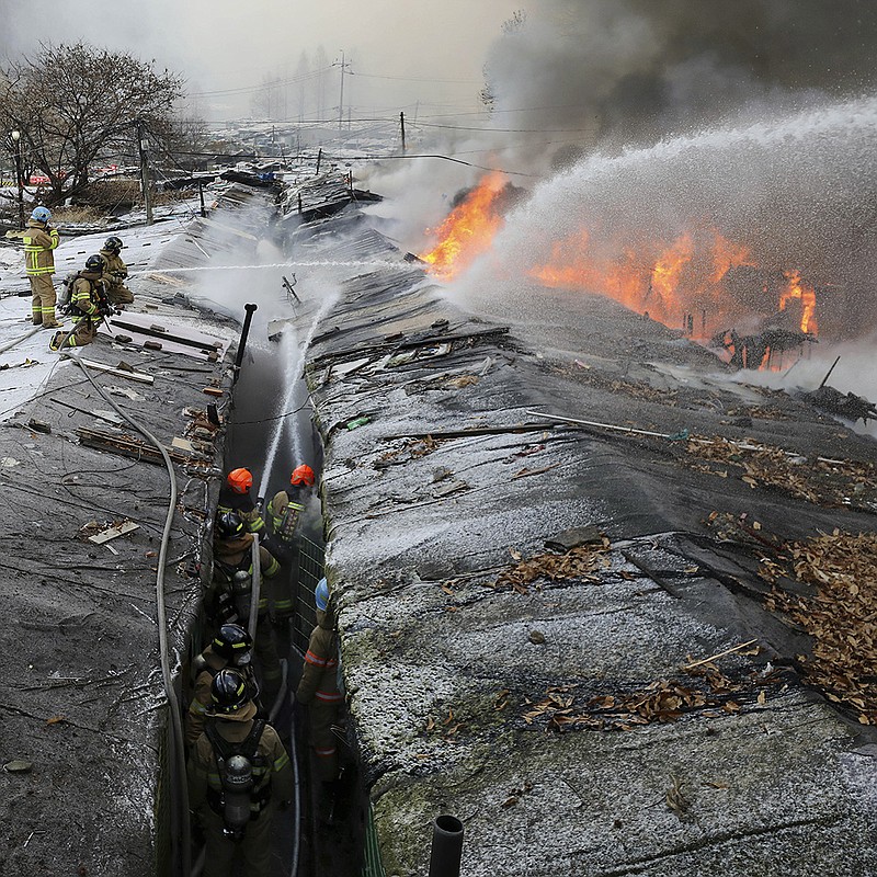 Firefighters battle a fire Friday at the Guryong shantytown in Seoul, South Korea. More than 60 homes were destroyed in the slum that is home to people mostly in their 60s or older, but no casualties were immediately reported. Dozens of firetrucks and 10 helicopters were dispatched along with hundreds of responders, officials said. More photos at arkansasonline.com/121fire/.
(AP/Newsis/Baek Dong-hyun)