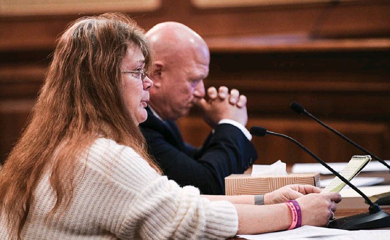 With tears running down her cheek, Patty Preiss tries to maintain her composure as she testifies before Missouri legislators Monday, Jan. 23, 2023, on behalf of legislation sponsored by Sen. Mike Bernskoetter, in background, who sponsored SB22. The bill would modify provisions relating to eligibility for parole. Preiss is the mother of Elizabeth Olten who, at age 8, was killed by 15-year-old Alyssa Bustamante on Oct. 21, 2009. Bustamante was tried as an adult and sentenced to life in prison. (Julie Smith/News Tribune photo)