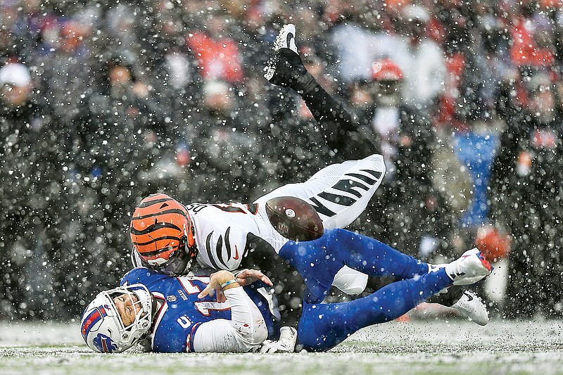 Bills quarterback Josh Allen takes a hit from Bengals defensive end Joseph Ossai during Sunday’s divisional round game in Orchard Park, N.Y. (Associated Press)