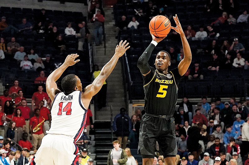 D’Moi Hodge of Missouri shoots a 3-pointer against the defense of Mississippi’s Tye Fagan during Tuesday night’s game in Oxford, Miss. (Associated Press)