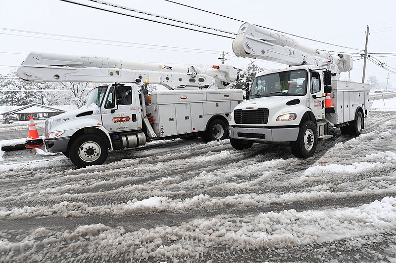 Utility trucks stage Wednesday, Jan. 25, 2023, at a gas station in West Fork. A combined 18,387 customer outages were reported by Southwestern Electric Power Company and Ozarks Electric Cooperative in Washington County.  (NWA Democrat-Gazette/Andy Shupe)