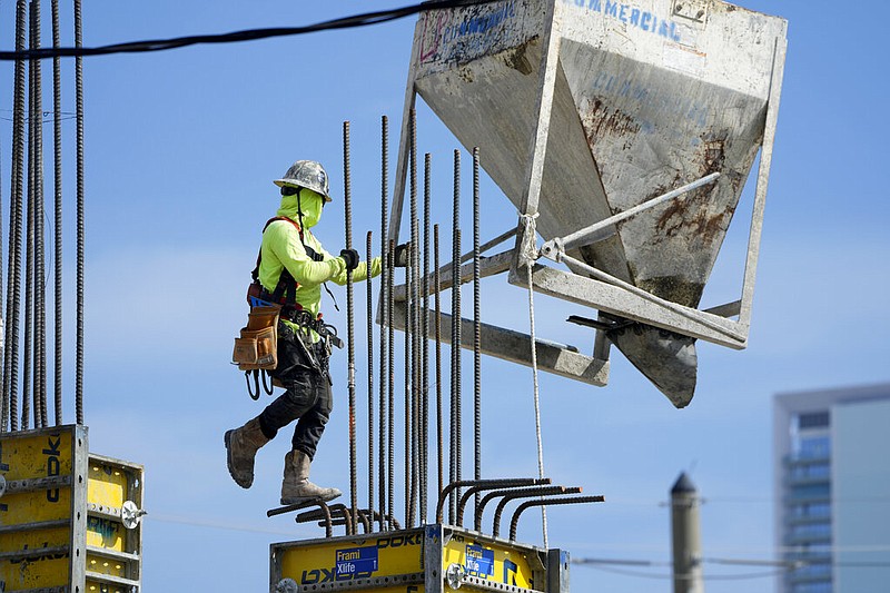 A worker guides a bin into position at a construction site in Miami on Tuesday, Jan. 24, 2023. (AP/Lynne Sladky)