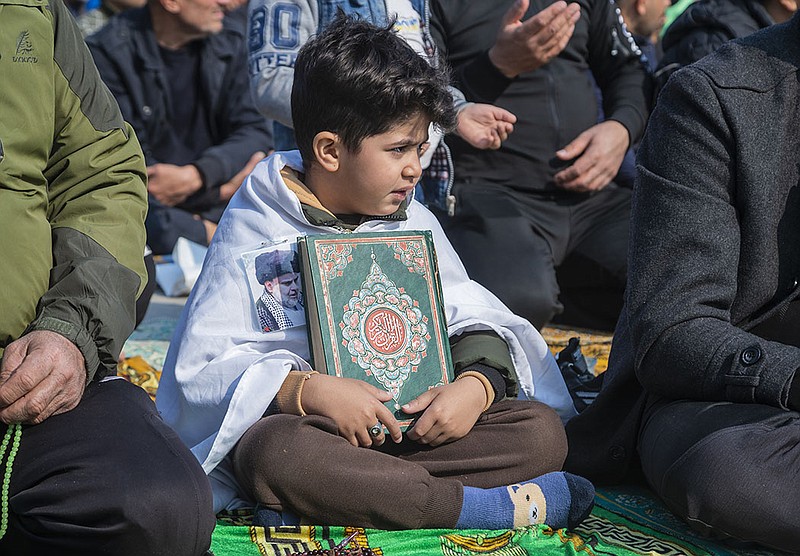A child holds a copy of the Koran at a protest during open-air Friday prayers in Baghdad.
(AP/Hadi Mizban)