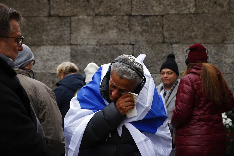 Zvika Karavany, 72, a Yemeni-born Israeli, wipes his tears in front of the Death Wall in the former Nazi German concentration and extermination camp Auschwitz during ceremonies marking the 78th anniversary of the liberation of the camp in Oswiecim, Poland, Friday, Jan. 27, 2023. (AP Photo/Michal Dyjuk)