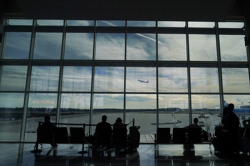 FILE - Travelers watch as a plane takes off from Hartsfield-Jackson Atlanta International Airport in Atlanta, Tuesday, Nov. 22, 2022. (AP Photo/Brynn Anderson, File)