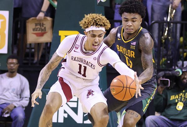 Arkansas forward Jalen Graham (11) reaches for the ball over Baylor guard Langston Love (13) in the second half of an NCAA college basketball game, Saturday, Jan. 28, 2023, in Waco, Texas. (Rod Aydelotte/Waco Tribune-Herald via AP)