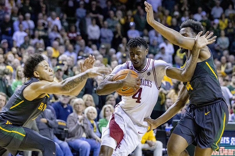 Arkansas guard Davonte Davis (4) drives between Baylor defenders Keyonte George, left, and LJ Cryer, right, during the second half of an NCAA college basketball game in Waco, Texas, Saturday, Jan. 28, 2023. (AP Photo/Gareth Patterson)