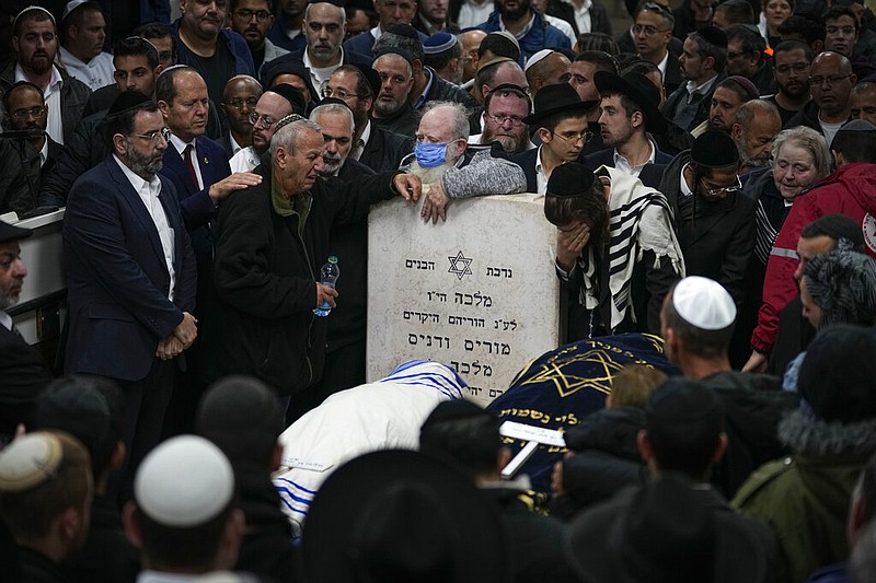 Mourners attend the funeral of Israeli couple Eli Mizrahi and his wife, Natalie, victims of a shooting attack Friday in east Jerusalem, at the cemetery in Beit Shemesh, Israel, early Sunday, Jan. 29, 2023. (AP/Ariel Schalit)