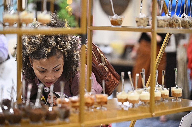 Justyce Gurley, a gown model for David’s Bridal, checks out all of the cake samples at Mickey’s Cakes and Sweets vendor booth Sunday, January 29, during the Arkansas Democrat-Gazette Bridal Show at the Statehouse Convention Center in Little Rock..(Arkansas Democrat-Gazette/Staci Vandagriff)