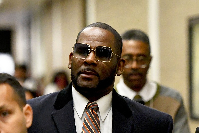 FILE - Musician R. Kelly, center, leaves the Daley Center after a hearing in his child support case on May 8, 2019, in Chicago. (AP Photo/Matt Marton, File)