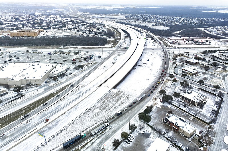 An icy mix covers Highway 114 on Monday, Jan. 30, 2023, in Roanoke, Texas. Dallas and other parts of North Texas are under a winter storm warning through Wednesday. (Lola Gomez/The Dallas Morning News via AP)