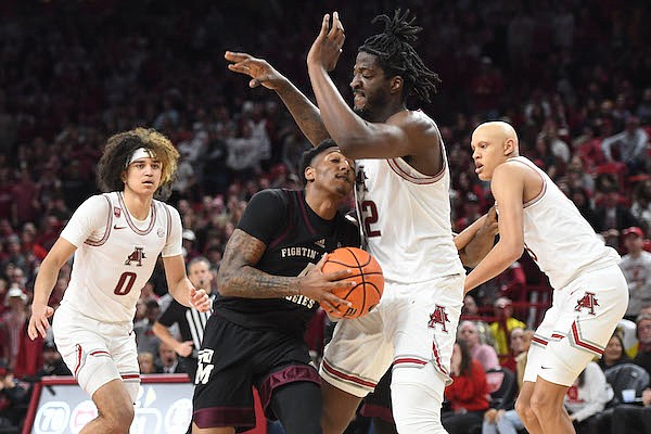 Texas A&M guard Wade Taylor IV (center) drives to the basket Tuesday, Jan. 31, 2023, as he is pressured by Arkansas forward Makhel Mitchell (22) during the second half of the Razorbacks' 81-70 win in Bud Walton Arena in Fayetteville.