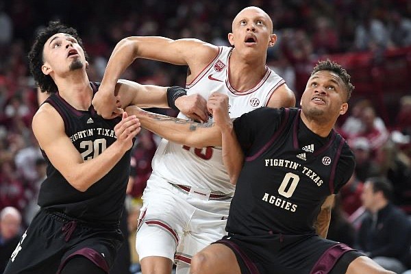 Arkansas guard Jordan Walsh (center) fights for position for a rebound Tuesday, Jan. 31, 2023, around Texas A&M guard Andrew Gordon (20) and Dexter Dennis (0) during the first half of play in Bud Walton Arena in Fayetteville.