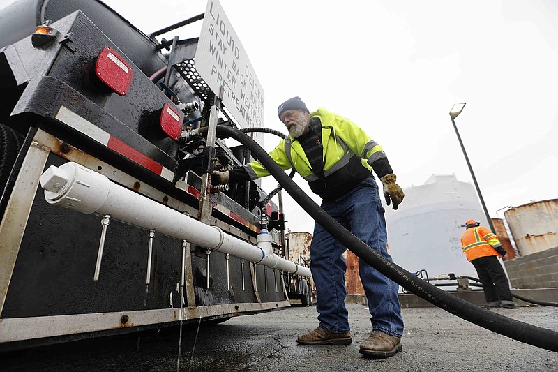 Chip O'Donnell with the Arkansas Department of Transportation hooks up a line as his truck is filled with deicer to treat roads on Tuesday, Jan. 31, 2023, in Little Rock. (Arkansas Democrat-Gazette/Thomas Metthe)
