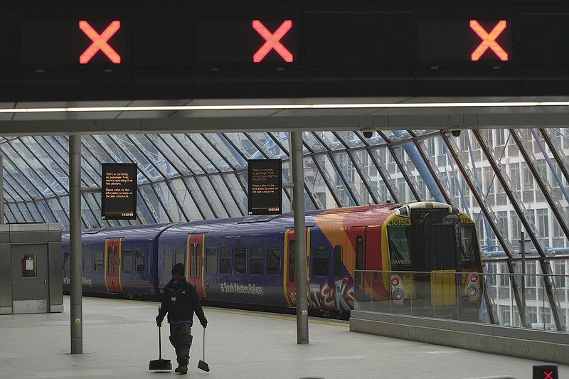 A worker cleans the floor in an near-empty Waterloo Station on Wednesday in London. More photos at arkansasonline.com/202strike/.
(AP/Kin Cheung)