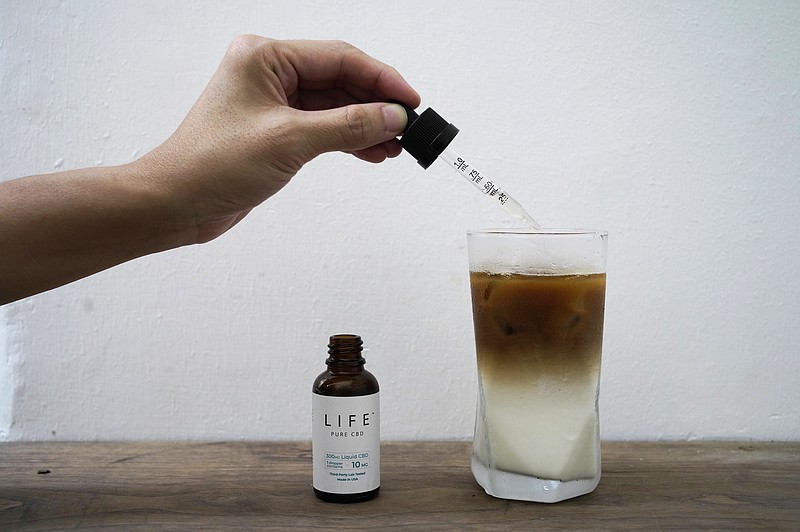 FILE - An employee adds drops of water-soluble CBD, or cannabidiol, an essential component of medical marijuana, into a coffee glass at the Found Cafe in Hong Kong on Sept. 13, 2020. (AP Photo/Vincent Yu, File)