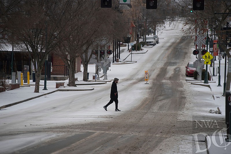 A pedestrian crosses a deserted Dickson St. Tuesday Jan. 31, 2023 while sleet begins to fall. The National Weather Service is calling for more precipitation this week with freezing rain expected Wednesday and Thursday. Visit nwaonline.com/photo for today's photo gallery. (NWA Democrat-Gazette/J.T. Wampler)