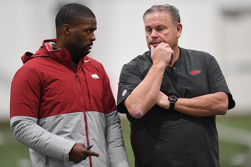 Arkansas co-defensive coordinator Travis Williams (left), shown with Coach Sam Pittman during a practice inside the Walker Pavilion in December, was an obvious choice when he was hired, according to Pittman. “Travis is obviously a very aggressive defensive guy. But right now, the portal makes you — and I’ve always been this way, but even more so now — you’d better hire recruiters. And recruiters are usually good people. So I did that with him,” Pittman said.
(NWA Democrat-Gazette/Andy Shupe)