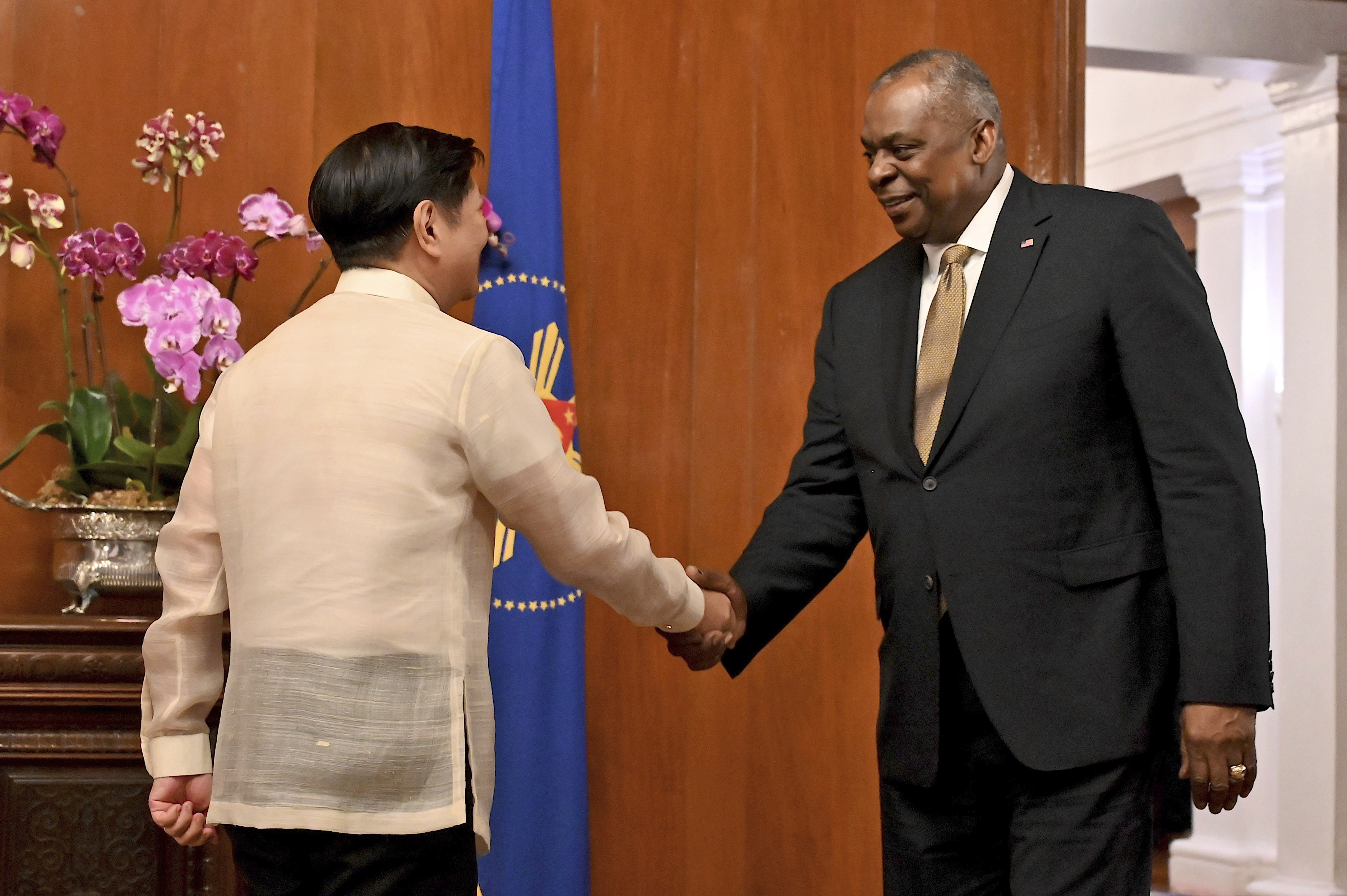 U.S. Secretary of Defense Lloyd James Austin III, right, shake hands with Philippine President Ferdinand Marcos Jr. during a courtesy call at the Malacanang Palace in Manila, Philippines on Thursday, Feb. 2, 2023. (Jam Sta Rosa/Pool Photo via AP)