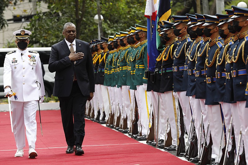 U.S. Defense Secretary Lloyd Austin, second from left, walks past military guards during his arrival at the Department of National Defense in Camp Aguinaldo military camp in Quezon City, Metro Manila, Philippines on Thursday February 2, 2023. (Rolex Dela Pena/Pool Photo via AP)