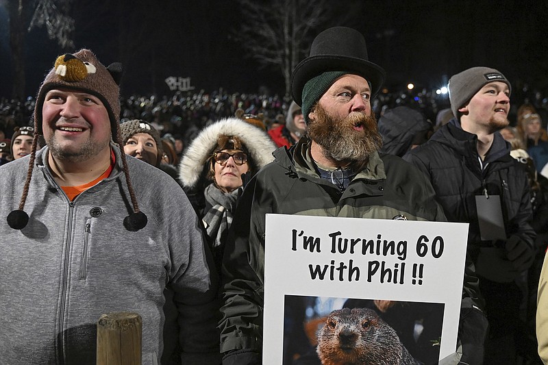 Rory Szwed, left, and Kent Rowan watch the festivities while waiting for Punxsutawney Phil, the weather prognosticating groundhog, to come out and make his prediction during the the 137th celebration of Groundhog Day on Gobbler's Knob in Punxsutawney, Pa., Thursday, Feb. 2, 2023. (AP Photo/Barry Reeger)