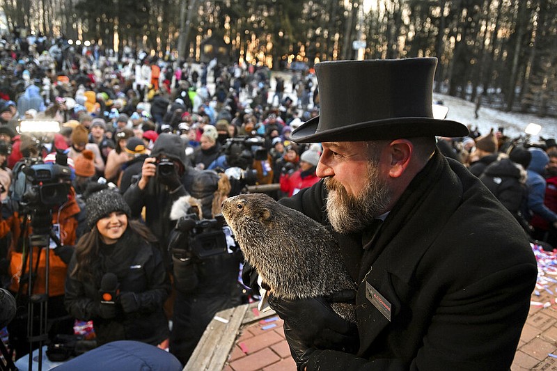 Groundhog Club handler A.J. Dereume holds Punxsutawney Phil, the weather prognosticating groundhog, during the 137th celebration of Groundhog Day on Gobbler's Knob in Punxsutawney, Pa., Thursday, Feb. 2, 2023. Phil's handlers said that the groundhog has forecast six more weeks of winter. (AP Photo/Barry Reeger)