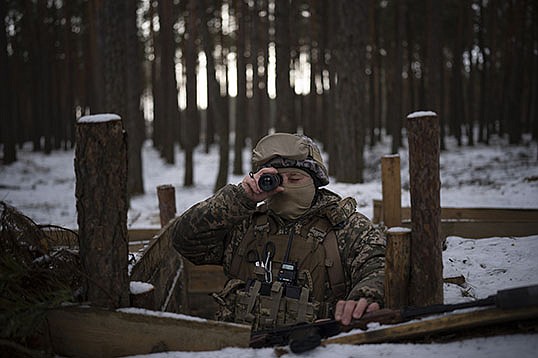 A Ukrainian soldier keeps watch for Belarusian troop activity Wednesday along the 650-mile frontier of marsh and woodland separating the countries.
(AP/Daniel Cole)