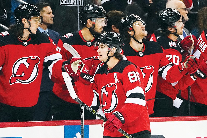 Jack Hughes celebrates with his Devils teammates after scoring a goal during a recent game against the Penguins in Newark, N.J. (Associated Press)