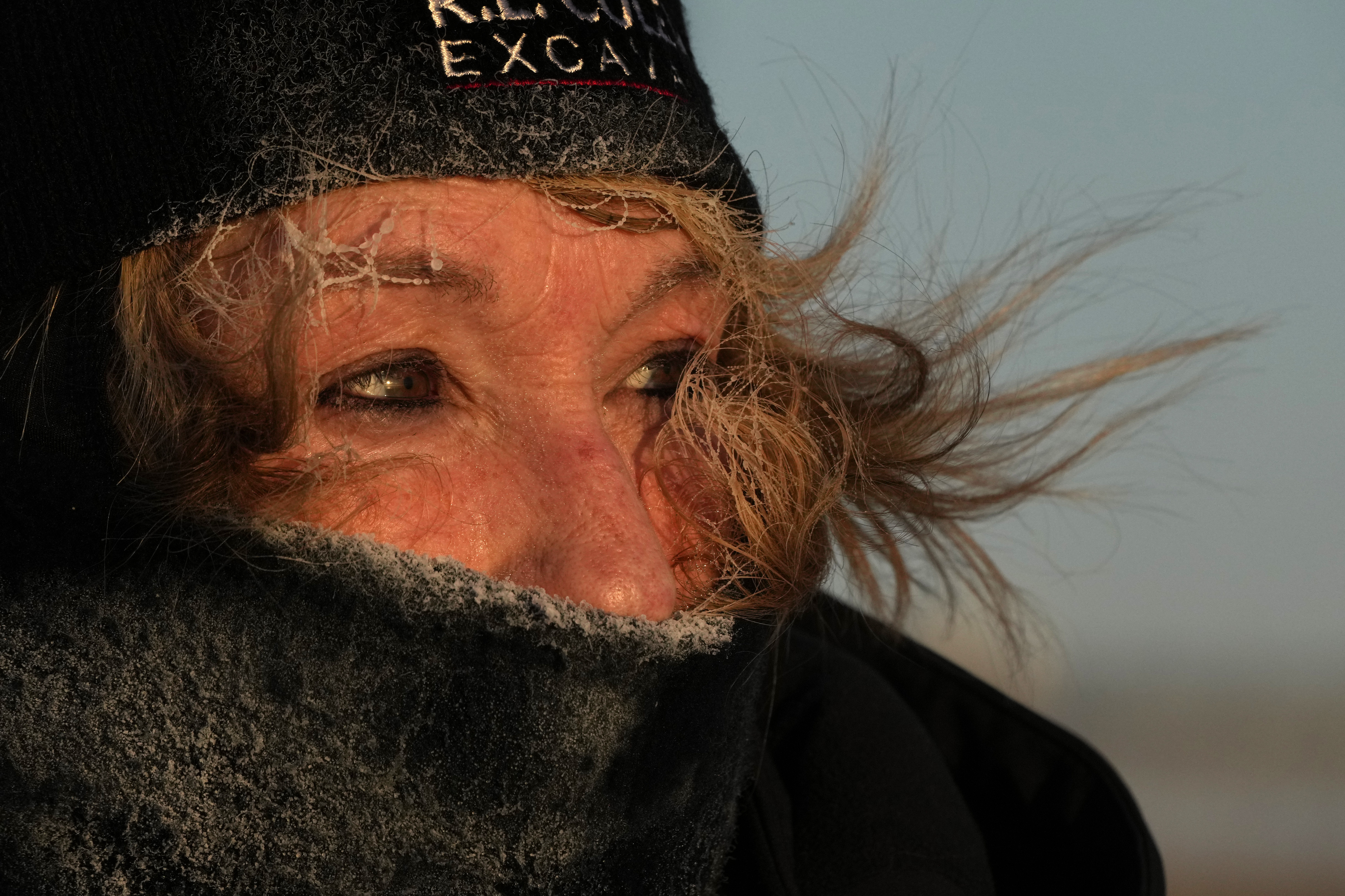 Frost clings to the hair of Joyce Love as she looks at arctic sea smoke on the coast of South Portland, Maine, Saturday, Feb. 4, 2023. The morning temperature was about -10 degrees Fahrenheit. (AP Photo/Robert F. Bukaty)