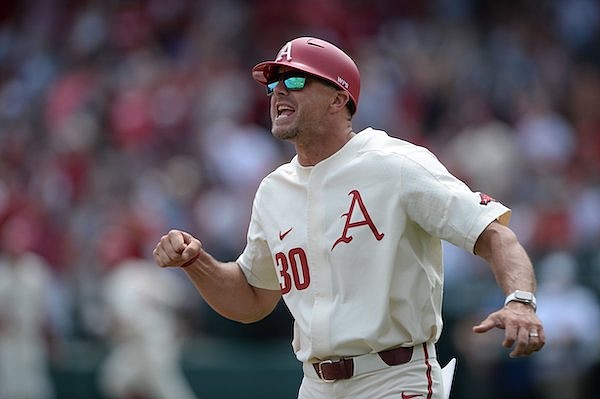 Arkansas assistant coach Nate Thompson cheers Saturday, May 22, 2021, as first baseman Brady Slavens' two-run home run leaves the park during the fourth inning of the Razorbacks' 9-3 win over Florida at Baum-Walker Stadium in Fayetteville.