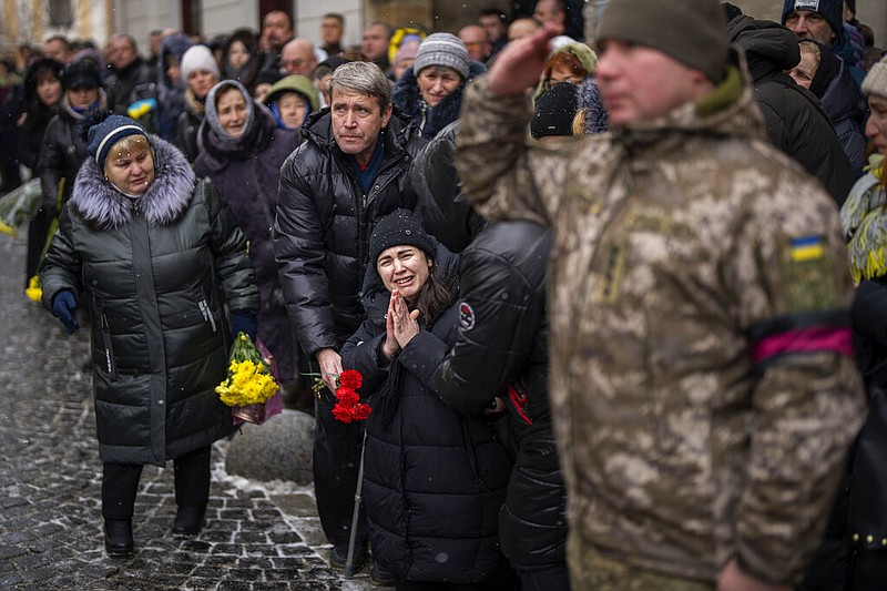 Anastasia, center, cries as soldiers carry the coffin of her brother Oleg Kunynets, a Ukrainian military servicemen who were killed in the east of the country, during his funeral in Lviv, Ukraine, Tuesday, Feb 7, 2023. (AP Photo/Emilio Morenatti)