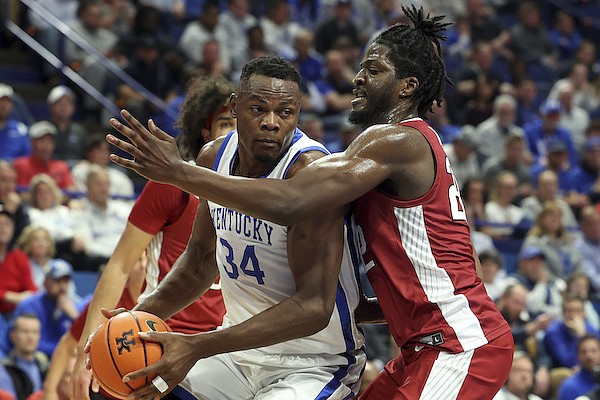 Kentucky's Oscar Tshiebwe (34) is defended by Arkansas' Makhel Mitchell, right, during the first half of an NCAA college basketball game in Lexington, Ky., Tuesday, Feb. 7, 2023. (AP Photo/James Crisp)