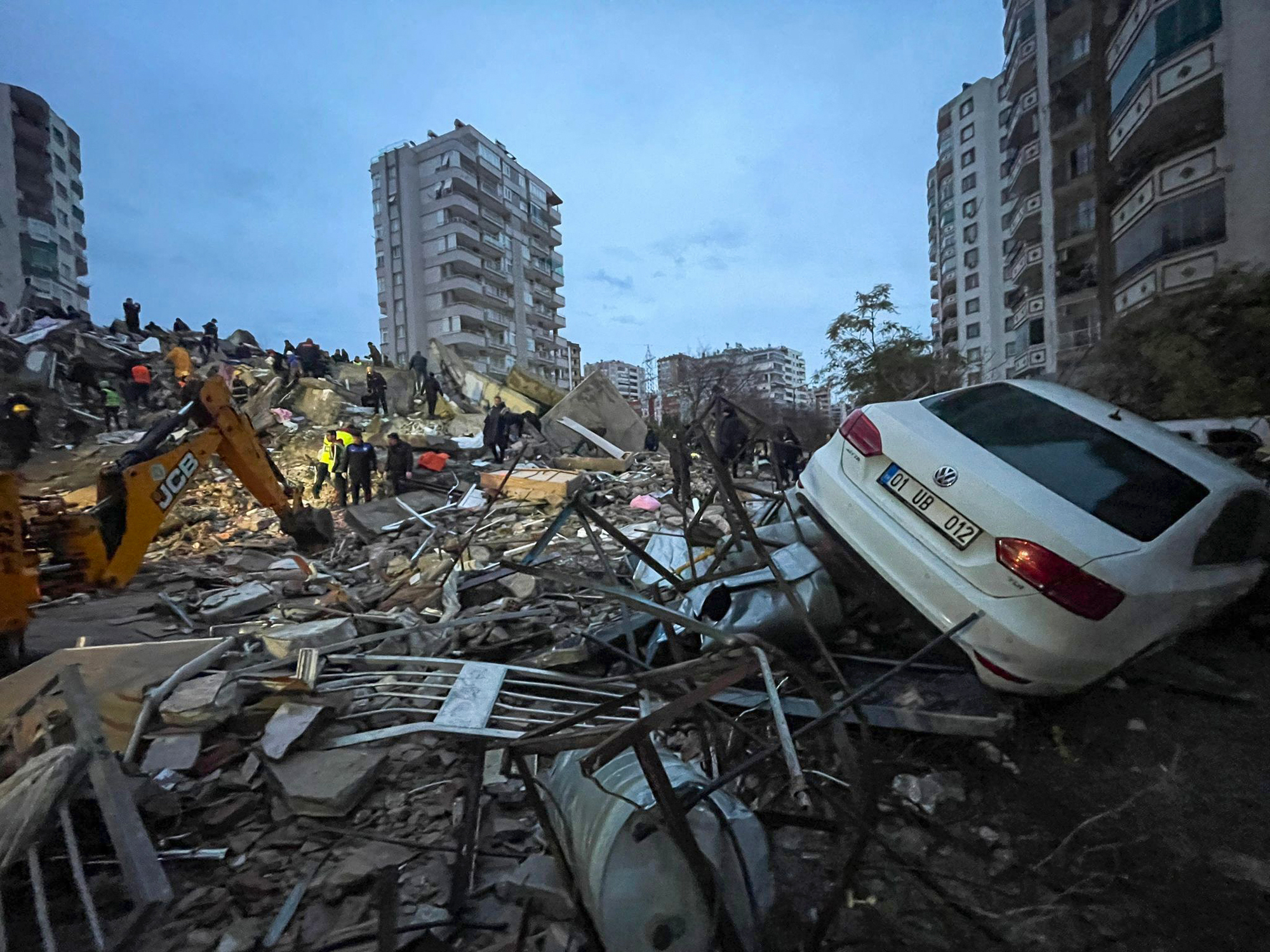 Emergency teams search for people in a destroyed building in Adana, Turkey, Monday, Feb. 6, 2023. A powerful quake has knocked down multiple buildings in southeast Turkey and Syria and many casualties are feared. (DIA Images via AP)