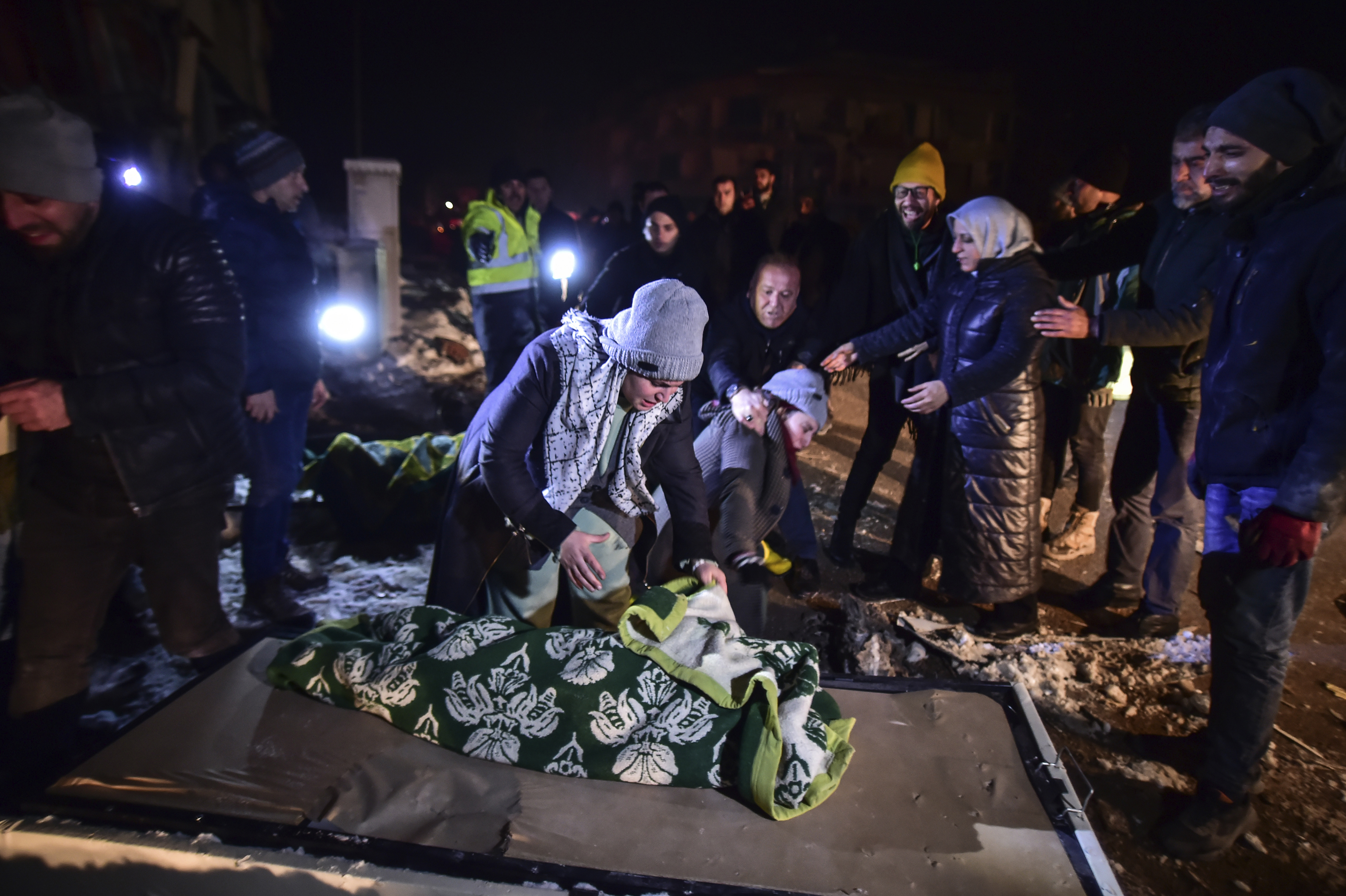 Relatives weep over the dead body of Goktug, a baby boy, in Elbistan, southern Turkey, late Tuesday, Feb. 7, 2023. Freezing cold temperatures are hindering rescue teams as they work to save people still trapped in the rubble after a 7.8-magnitude earthquake ripped through the region in the early morning hours Monday. Officials expect the number of reported deaths to increase significantly as operations continue. (Ismail Coskun/IHA via AP)