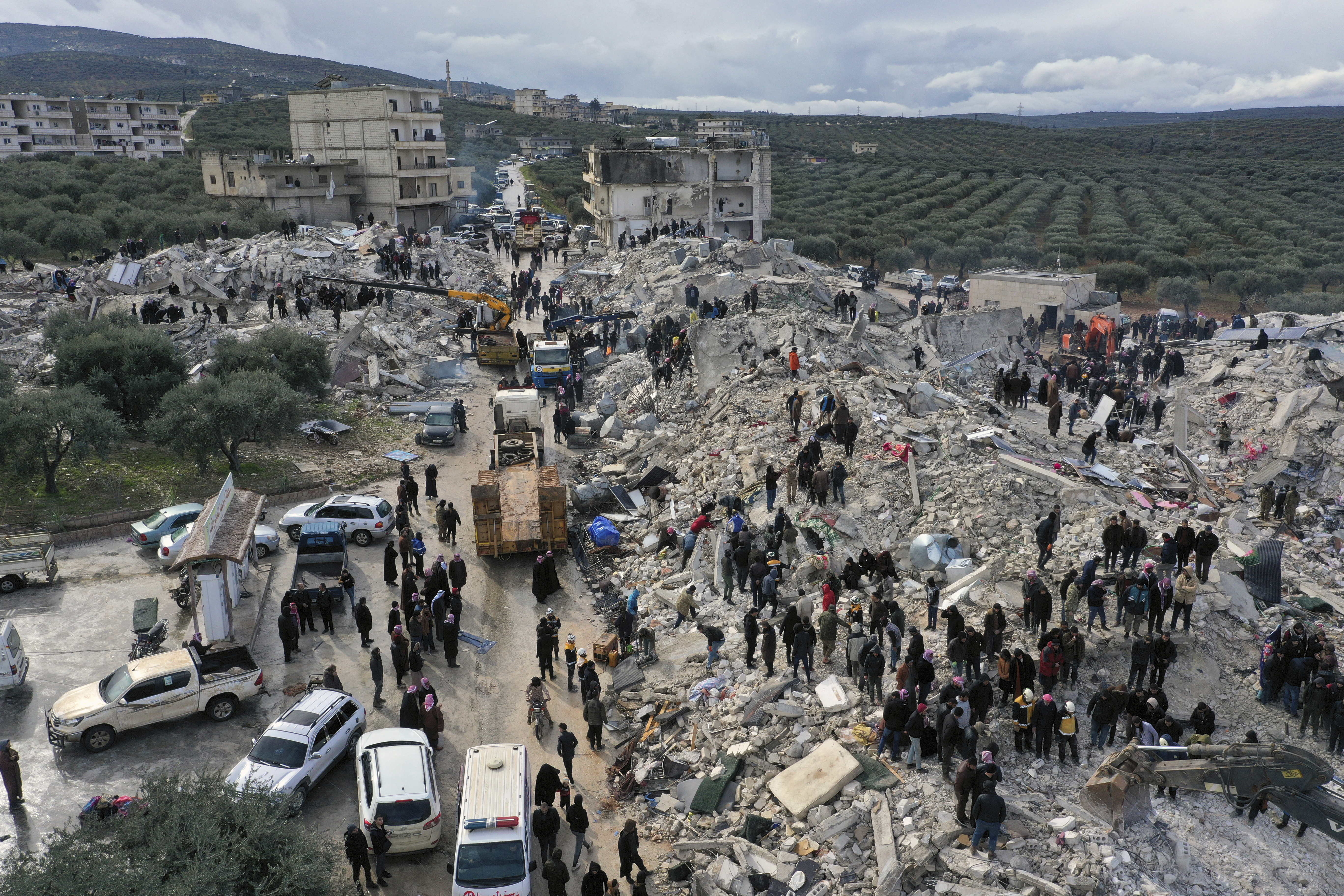 Civil defense workers and residents search through the rubble of collapsed buildings in the town of Harem near the Turkish border, Idlib province, Syria, Monday, Feb. 6, 2023. A powerful earthquake has caused significant damage in southeast Turkey and Syria and many casualties are feared. Damage was reported across several Turkish provinces, and rescue teams were being sent from around the country. (AP Photo/Ghaith Alsayed)