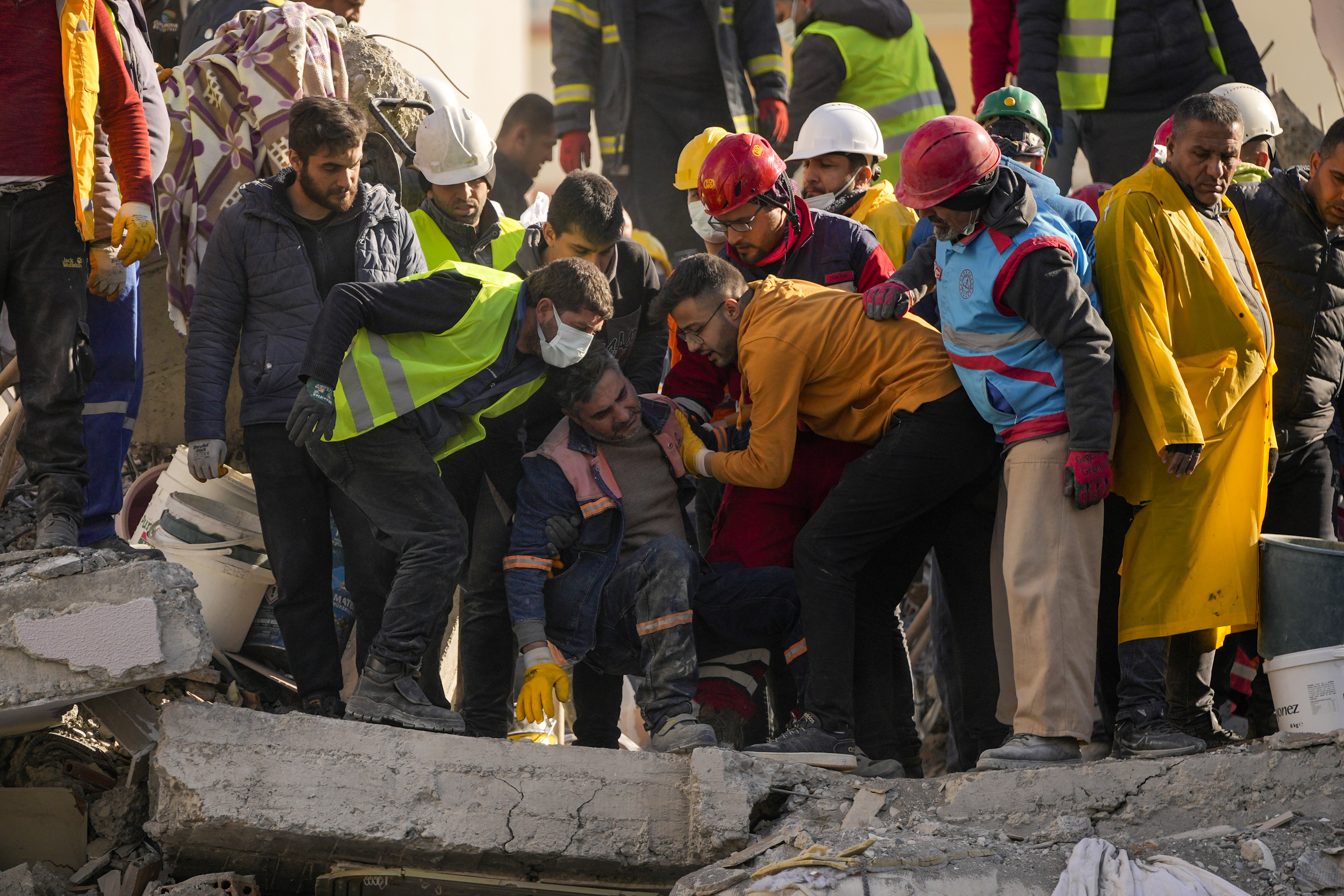 An emergency rescue team member is comforted by teammates after they found two bodies of people in a destroyed building in Adana, Turkey, Tuesday, Feb. 7, 2023. Rescuers raced Tuesday to find survivors in the rubble of thousands of buildings brought down by a powerful earthquake and multiple aftershocks that struck eastern Turkey and neighbouring Syria. (AP Photo/Francisco Seco)