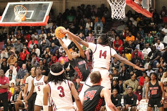 Deriyon Graydon of Pine Bluff blocks a shot by Jordan Rasberry of White Hall in the first half Tuesday at Pine Bluff High School's McFadden Gymnasium. (Special to The Commercial/Jamie Hooks)
