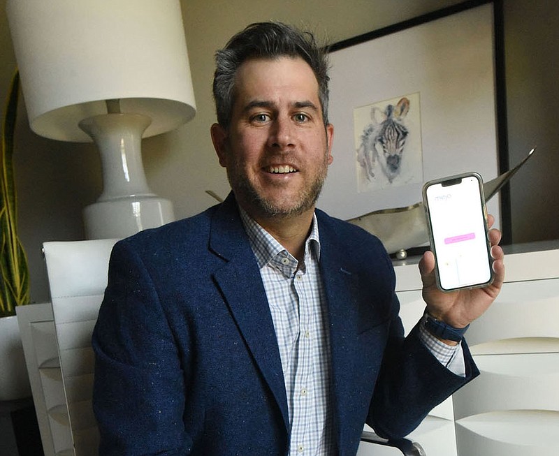 Ryan Sheedy in his office on Aug. 24 2022 shows his Mejo app for caregivers of medically complex children. He's speaking at a patient advocacy summit in San Diego in September..(NWA Democrat-Gazette/Flip Putthoff)