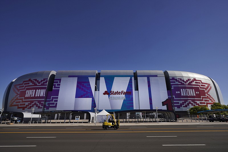 AP photo by Matt York / Workers outside of State Farm Stadium on Feb. 2 prepare the venue for Super Bowl LVII, which is Sunday in Glendale, Ariz.