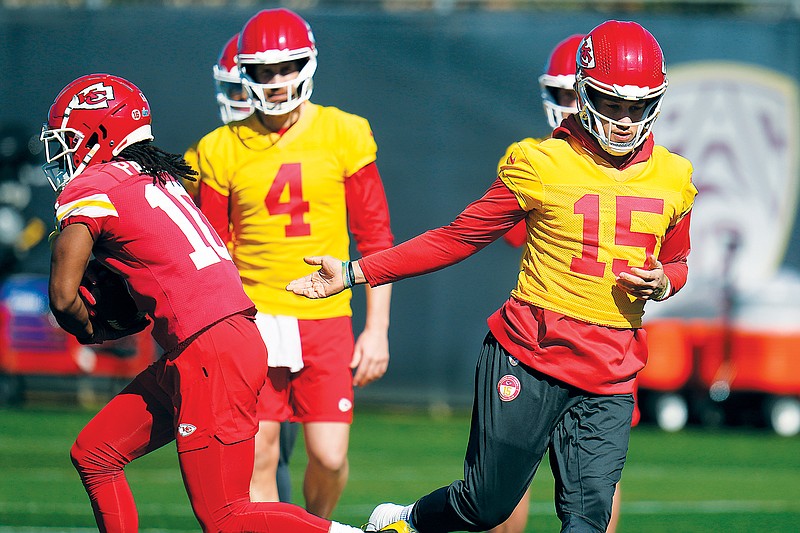 Chiefs quarterback Patrick Mahomes hands the ball off to running back Isiah Pacheco as backup quarterback Chad Henne looks on during practice Thursday in Tempe, Ariz. (Associated Press)