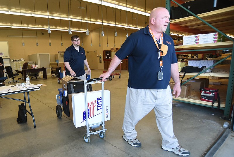 Staff Photo by Matt Hamilton / Machine tech Steve Gaston, front, and Nate Foster, assistant administrator of elections, take a set of election materials out to a waiting car at the Hamilton County Election Commission for last year's primary on May 2.