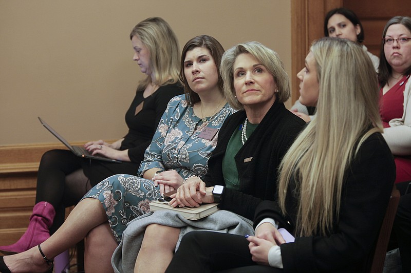 Kansas state Rep. Barb Wasinger, center, R-Hays, watches a Kansas Senate health committee hearing on a proposal to define male and female in Kansas law based on people's anatomy at birth, Wednesday, Feb. 15, 2023, at the Statehouse in Topeka, Kan. She's flanked by, left, Brittany Jones, attorney and lobbyist for the conservative group Kansas Family Voice, and right, Riley Gaines, a former University of Kentucky swimmer who's spoken against allowing transgender athletes to compete in girls' and women's sports. (AP Photo/John Hanna)