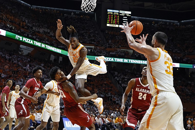 Tennessee guard Jahmai Mashack (15) collides with Alabama forward Nick Pringle (23) as he passes the ball to forward Uros Plavsic (33) during the first half of an NCAA college basketball game Wednesday, Feb. 15, 2023, in Knoxville, Tenn. (AP Photo/Wade Payne)