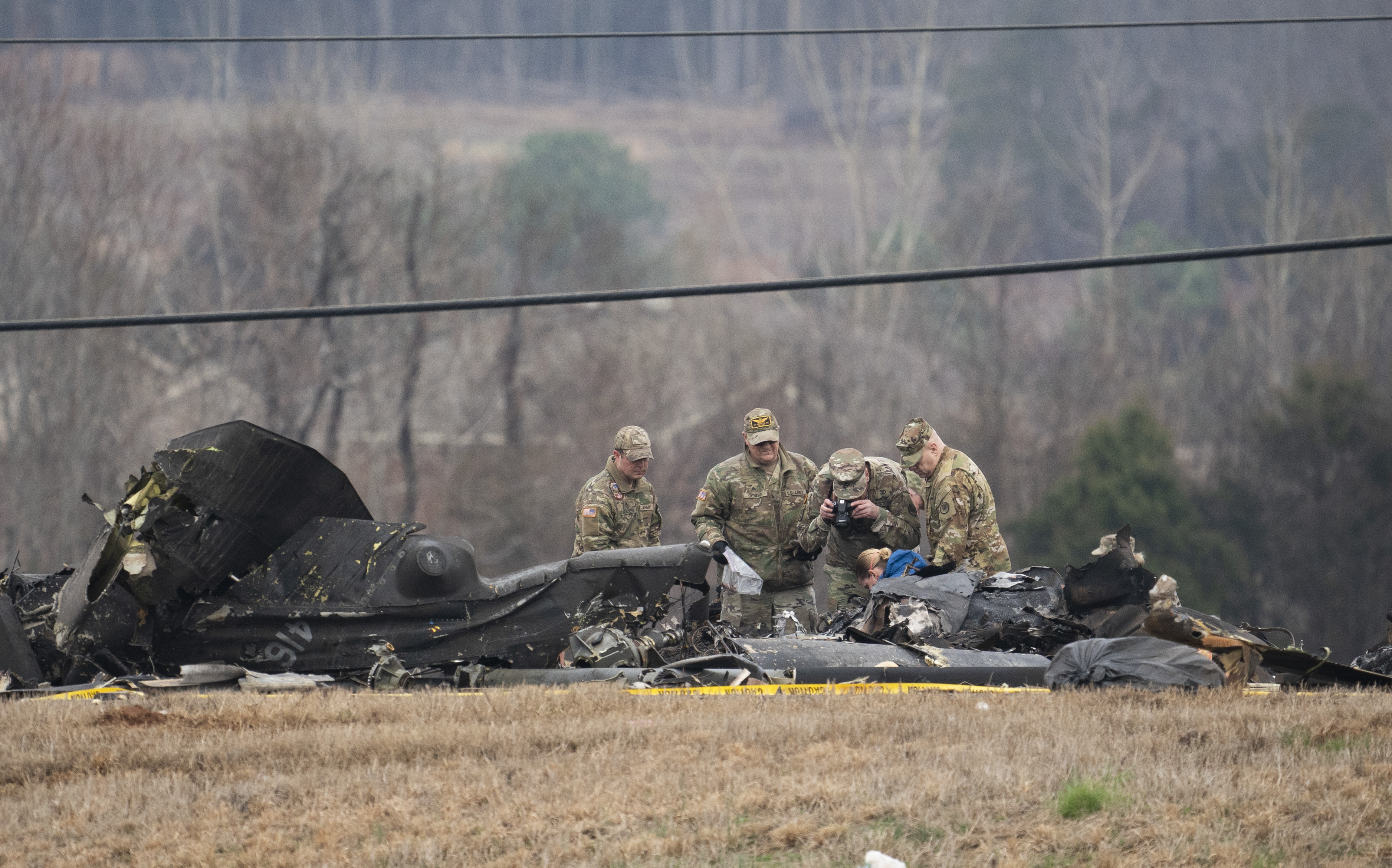 Military personnel and investigators search through debris from a Tennessee National Guard Blackhawk helicopter crash that killed some crew members Thursday, Feb. 16, 2023 in Harvest, Ala. Brig. Gen. Warner Ross said Wednesday that two members of the Tennessee National Guard were killed during a flight-training mission. (George Walker IV/The Tennessean via AP)