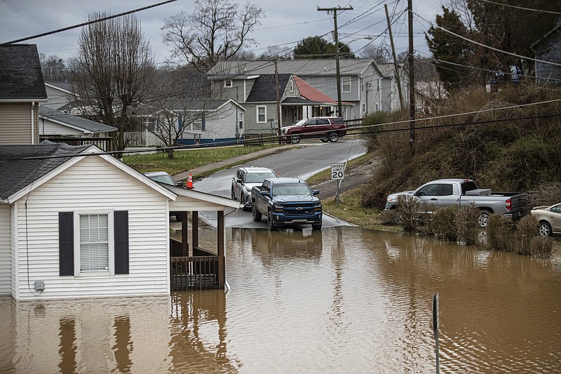 Flood water enters homes at the intersection of McGhee and Mason Street on Friday, Feb. 17, 2023, in Milton, W.Va. The flooding came amid a string of thunderstorms that inundated the South and dumped nearly 3 inches (8 centimeters) of rain in parts of West Virginia.  (Sholten Singer/The Herald-Dispatch via AP)