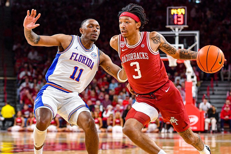 Arkansas guard Nick Smith Jr. (3) drives as Florida guard Kyle Lofton (11) defends, Saturday, Feb. 18, 2023, during the second half of the Razorbacks’ 84-65 win over the Gators at Bud Walton Arena in Fayetteville.